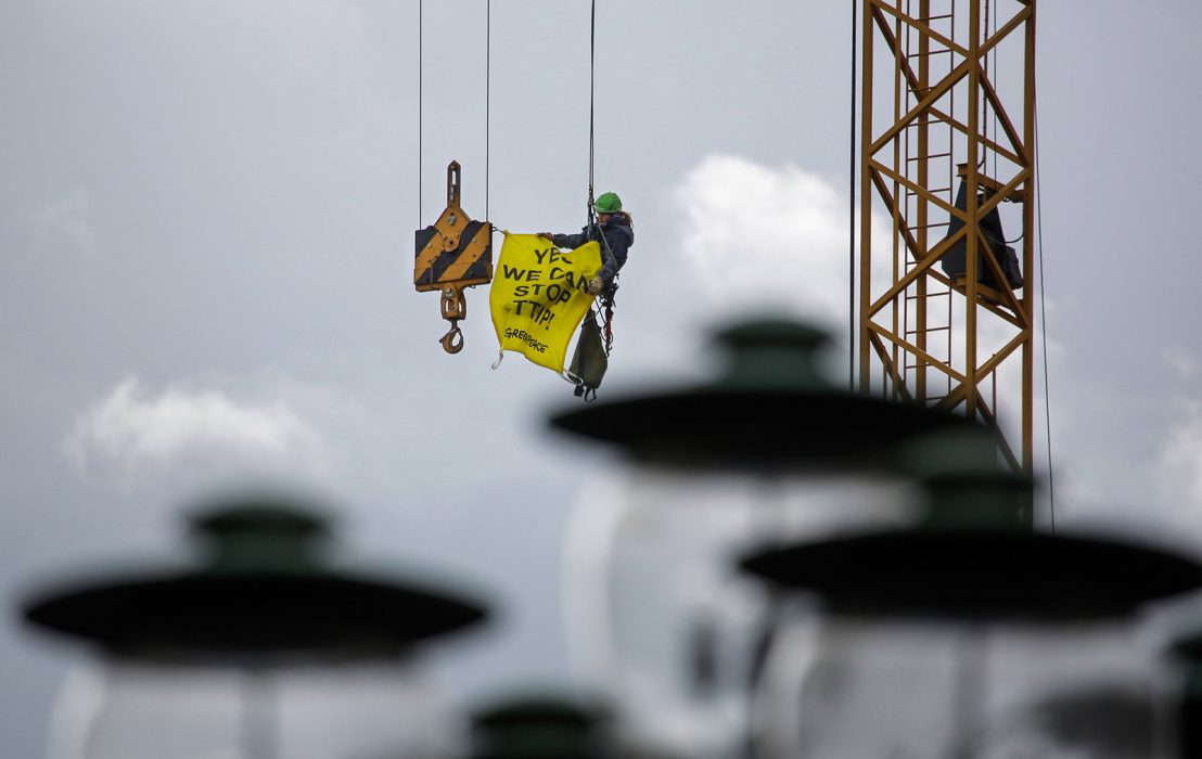 En aktivist från miljöorganisationen Greenpeace med en banderoll som säger ”Ja vi kan stoppa TTIP !” hänger från byggkran under en demonstration mot TTIP och CETA i Hannover , Tyskland , lördag den 23 april 2016