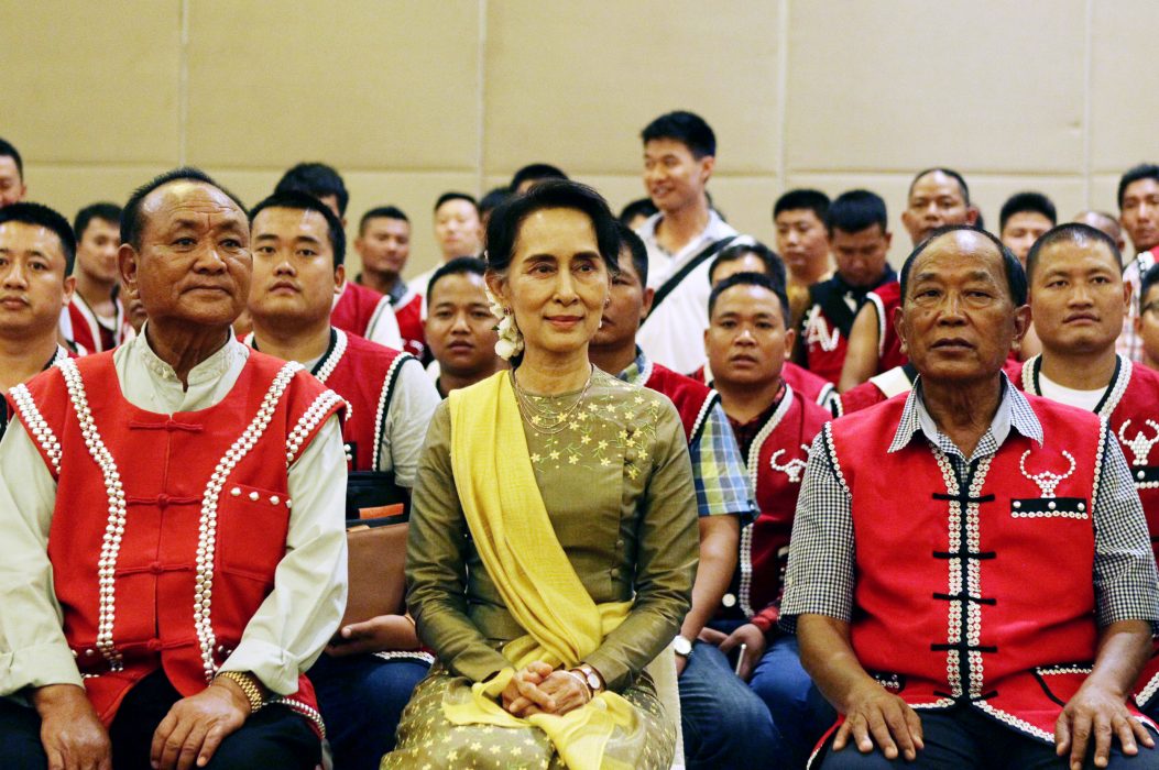 Burmas utrikesminister Aung San Suu Kyi sitter med medlemmar av United Wa State Army (UWSA) när de poserar för fotograferna efter ett möte mellan regeringen och väpnade etniska grupper fredag 29 juli i den nya huvudstaden Naypyitaw