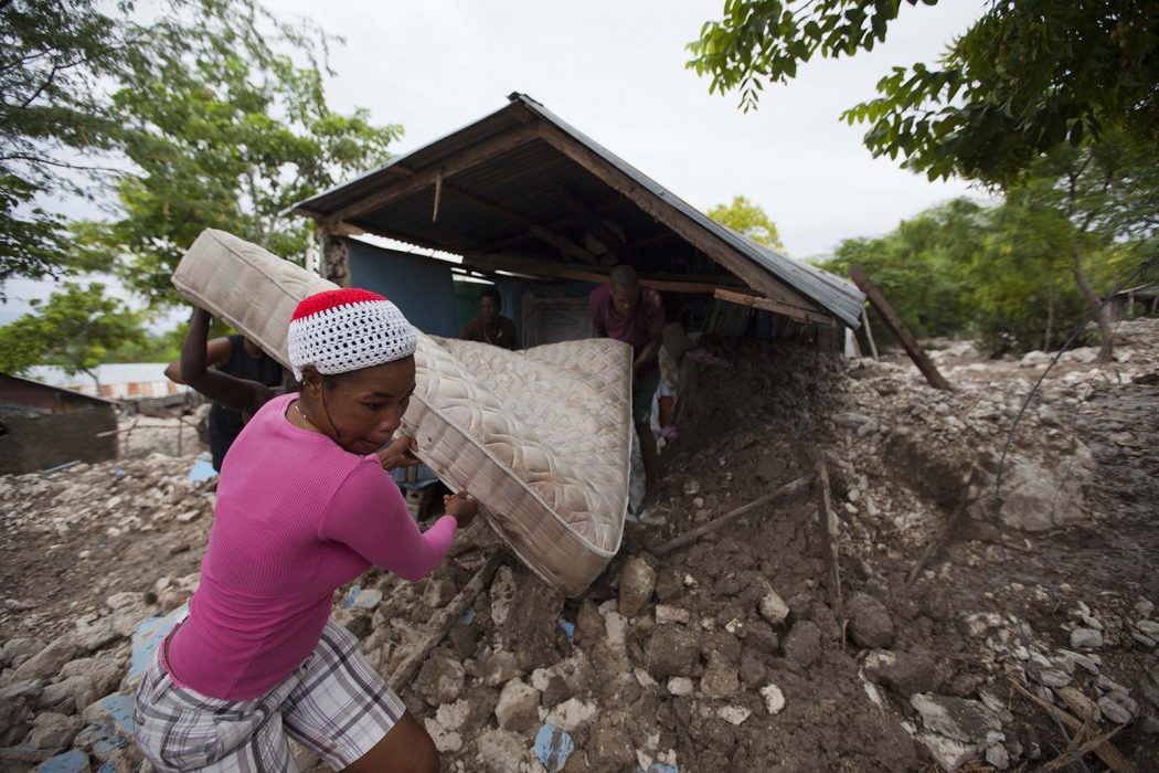En kvinna i Haiti räddar en madrass under stormen Erika, som drabbade flera karibiska öar i augusti 2015