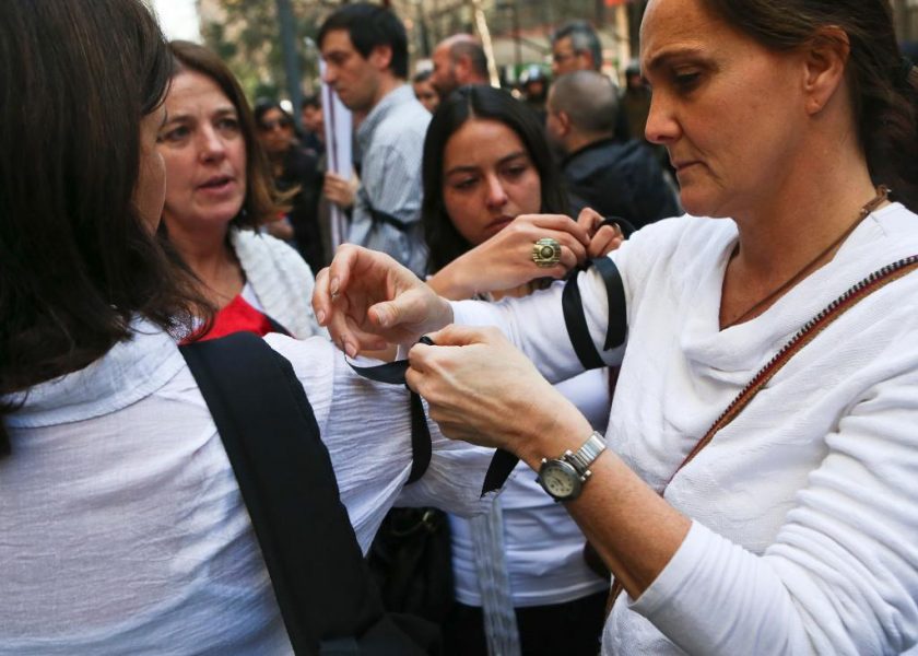 Esteban Felix/AP/TT | Kvinnor knyter svarta band runt sina armar i sorg över att Chiles författningsdomstol beslutat att avkriminalisera abort i vissa fall.