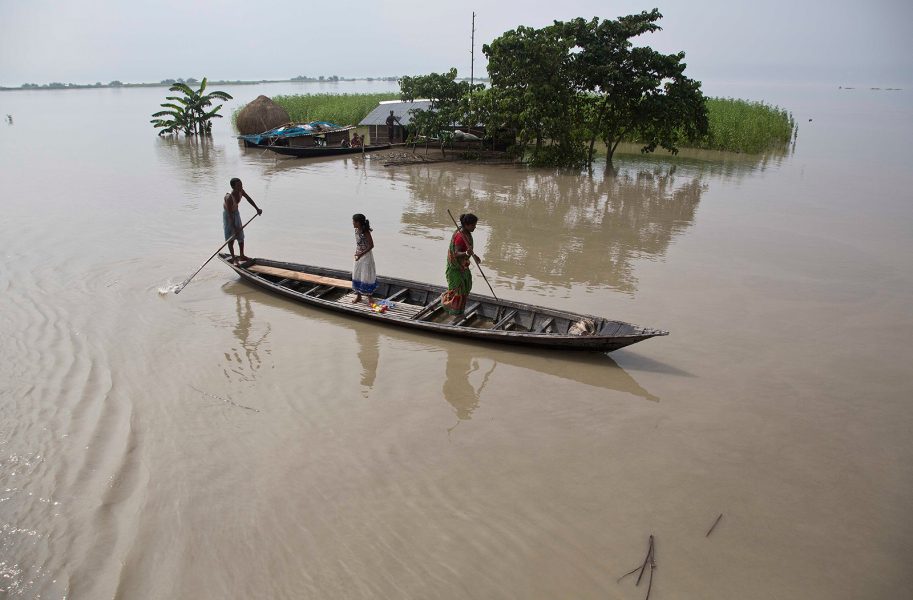 Anupam Nath/AP/TT | Invånare lämnar den översvämmade byn Pokoria i indiska Assam för att söka efter något mer höglänt område att bosätta sig i.