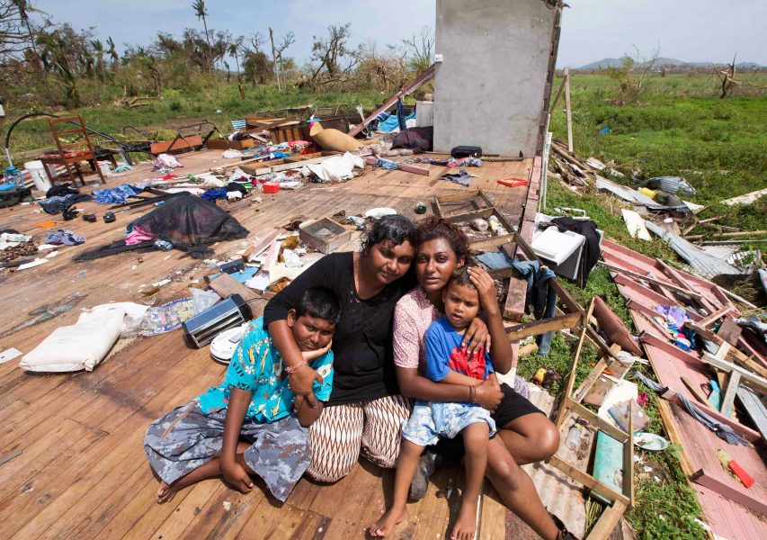 Brett Phibbs/AP/TT | Sanjogeeta Kiran med sin syster Sulva Kiran och hennes barn Shivendera och Raajeen sitter i resterna av sitt hem i Raki Raki, Fiji, efter att cyklon Winston drabbat önationen i februari 2016.