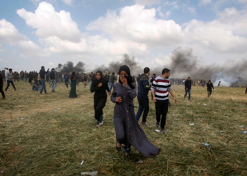 Adel Hana/AP Photo/TT | Palestinier flyr undan tårgasen under fredagens demonstration.