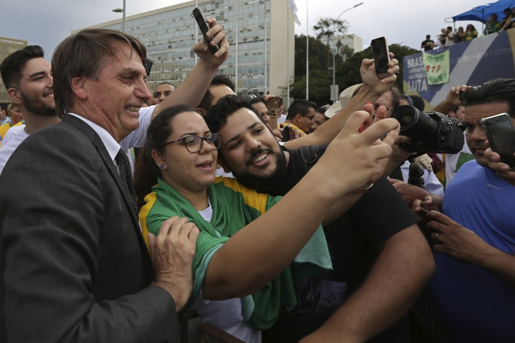 Eraldo Peres/AP/TT | Ultrahögerkandidaten och kongressledamoten Jair Bolsonaro ställer upp på bild med anhängare vid en demonstration i Brasilia tidigare i april.