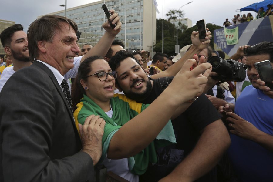 Eraldo Peres/AP/TT | Ultrahögerkandidaten och kongressledamoten Jair Bolsonaro ställer upp på bild med anhängare vid en demonstration i Brasilia tidigare i april.