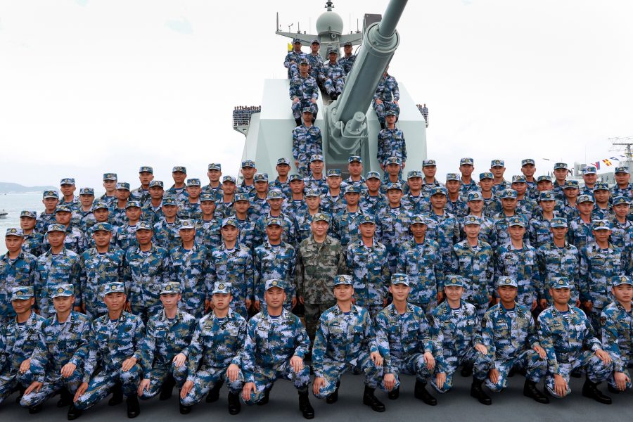 Li Gang/Nya Kina/AP | Kinas president Xi Jinping, i mitten, poserar tillsammans med soldater ombord på ett krigsfartyg.