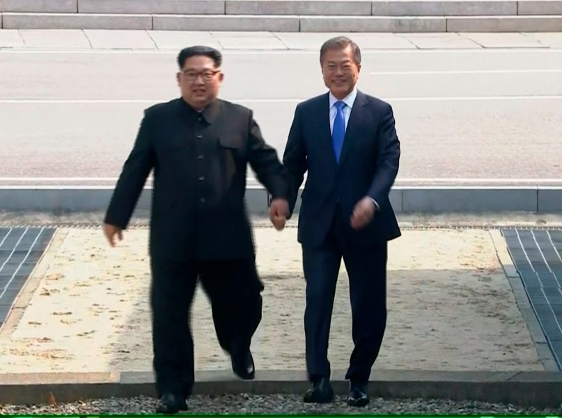 KBS/AP | Kim Jong-Un och Moon Jae-In håller hand när de tar steget in i Sydkorea.