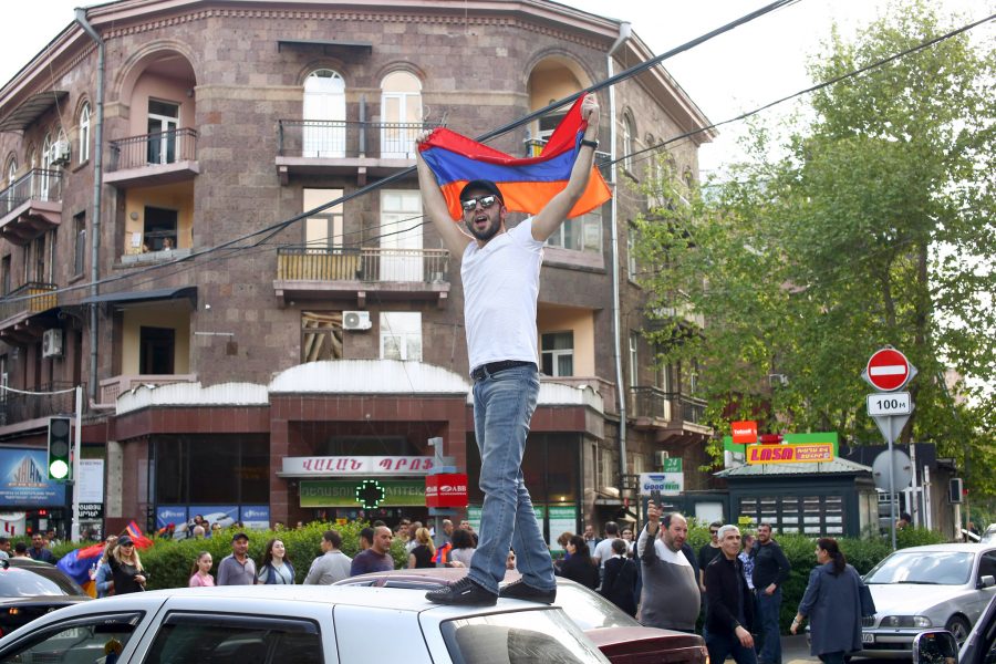 Hrant Khactaryan/AP/TT | En man i Jerevan firar att Serzj Sargsian avgått som Armeniens premiärminister.
