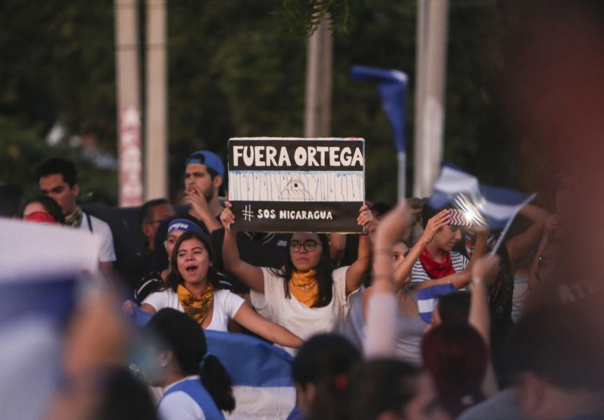 Alfredo Zuniga/AP/TT | En kvinna håller upp en skylt med texten "Avgå Ortega" under protester i söndags mot president Daniel Ortegas regering i Nicaraguas huvudstad Managua.