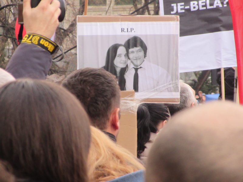 En demonstrant i Slovakiens huvudstad Bratislava håller upp en bild på journalisten Jan Kuciak och hans flickvän Martina Kusnirova, som båda mördades i februari förra året.