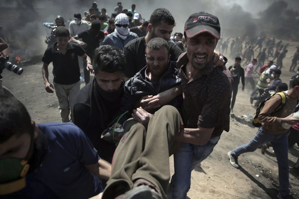 Khalil Hamra/AP/TT | En skottskadad palestinier bärs undan av andra demonstranter vid protesterna på Gazaremsan.