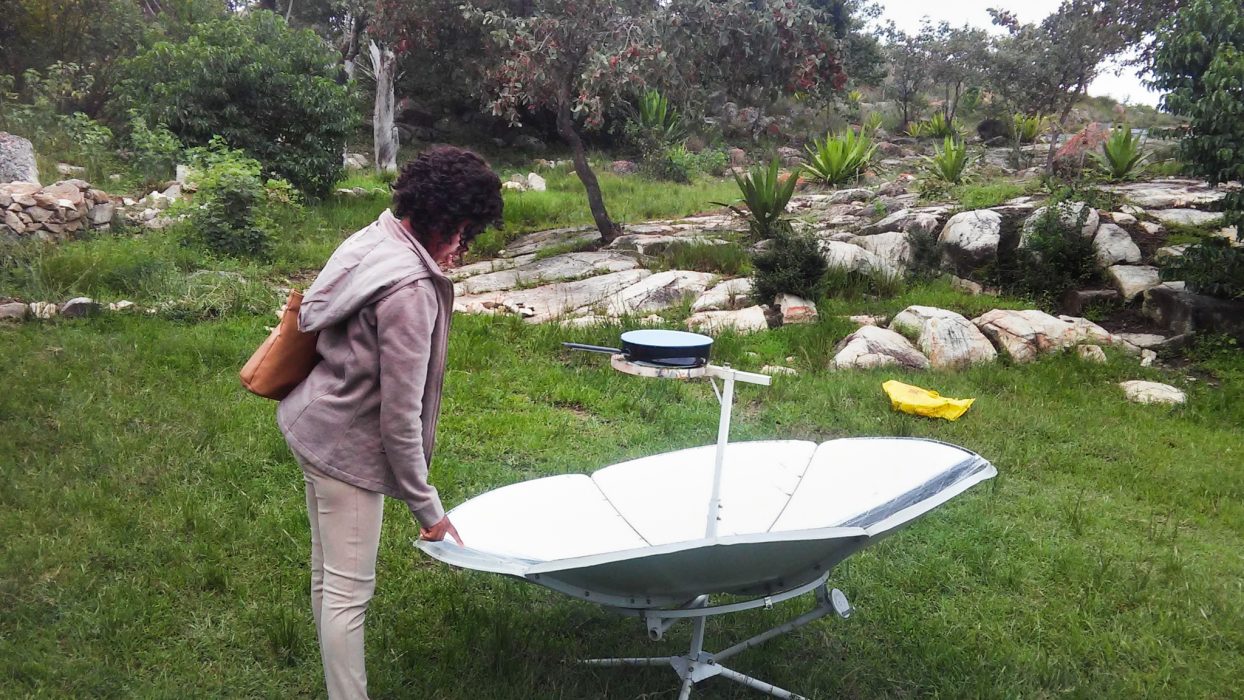 Tonderayi Mukeredzi/IPS | En kvinna tittar på en soldriven spis på en solenergimässa i Rusape, Zimbabwe.