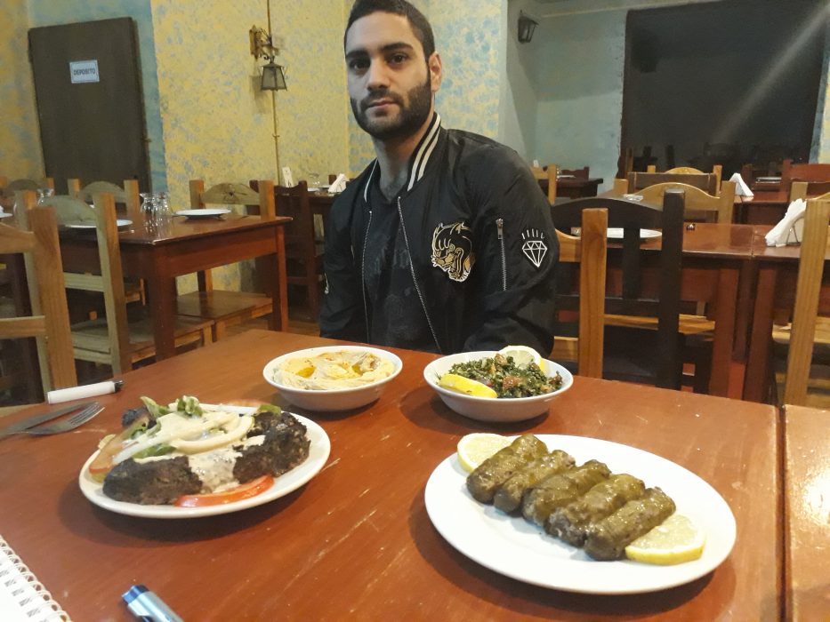 Daniel Gutman/IPS | Fares al Badwan, som flydde till Argentina för att undkomma att bli inkallad när kriget i Syrien började 2011, visar upp en del av den mat som serveras på familjens restaurang i Buenos Aires.