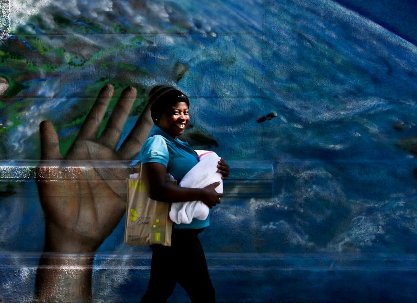 Esteban Felix/AP Photo/TT | Haitisk kvinna bär på ett barn i Santiago, Chile, nov 2017.