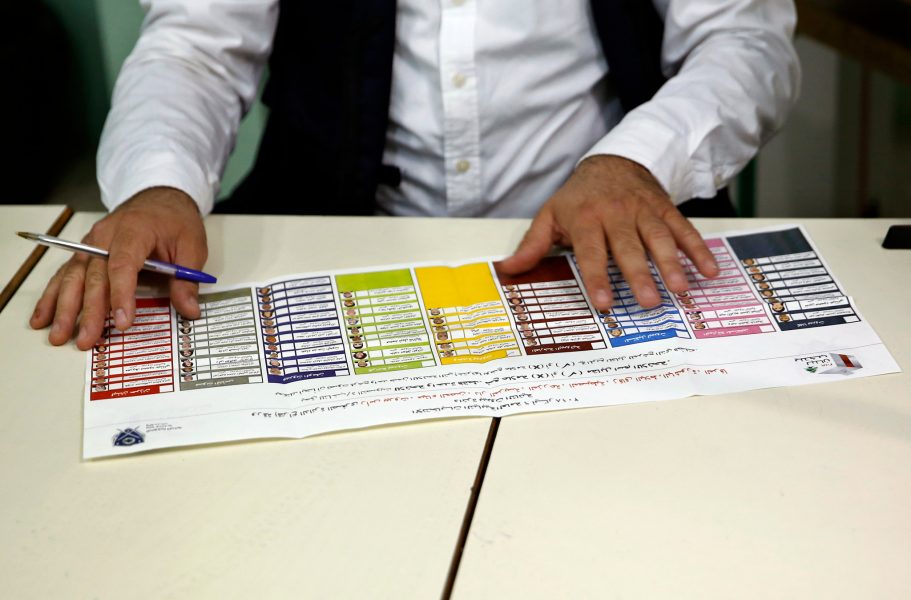 Bilal Hussein/AP/TT | En tjänsteman vid en vallokal i Beirut visar upp en röstsedel.