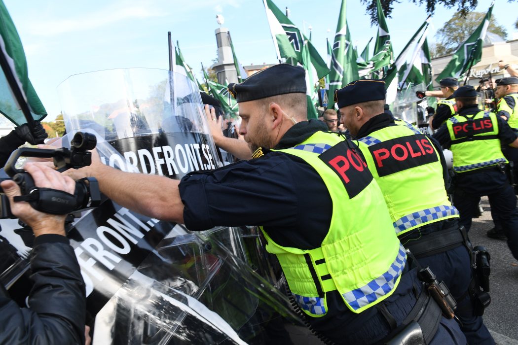 Fredrik Sandberg/TT | Nordiska motståndsrörelsens (NMR) anhängare hejdas av polis under en demonstration i Göteborg förra året.
