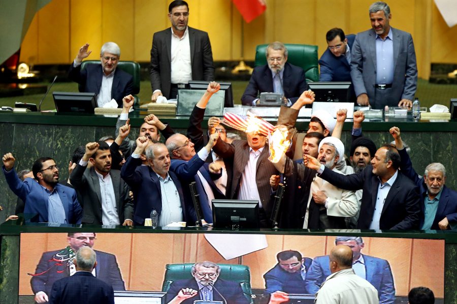 AP/TT | Iranska parlamentsledamöter bränner två pappersark som föreställer den amerikanska flaggan och kärnenergiavtalet, samtidigt som de sjunger antiamerikanska sånger i parlamentet i Teheran.