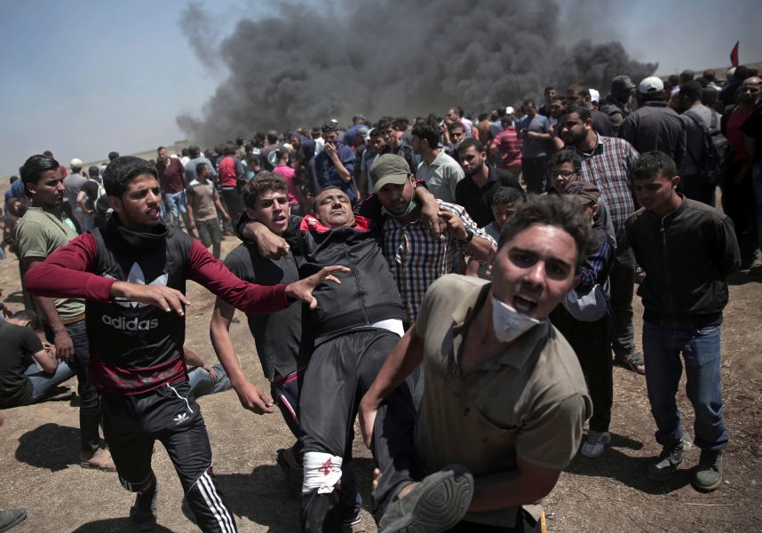 Khalil Hamra/AP/TT | Palestinska demonstranter bär en skadad man som skjutits under protesterna.