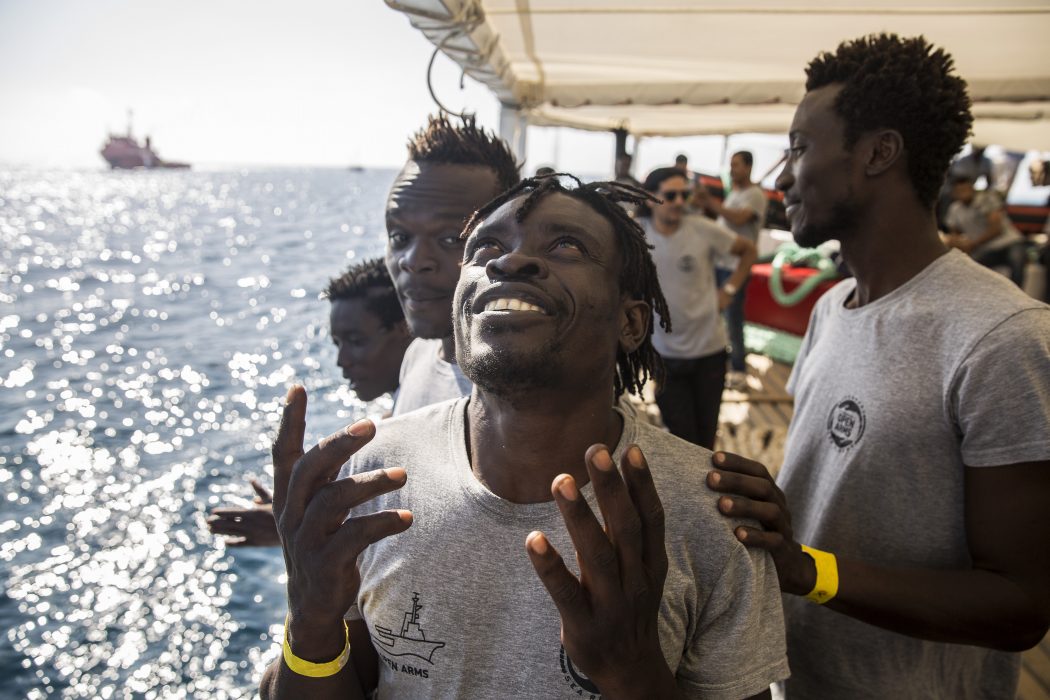 Olmo Calvo/AP/TT | Människor ombord på ett räddningsfartyg som närmar sig Barcelonas hamn.