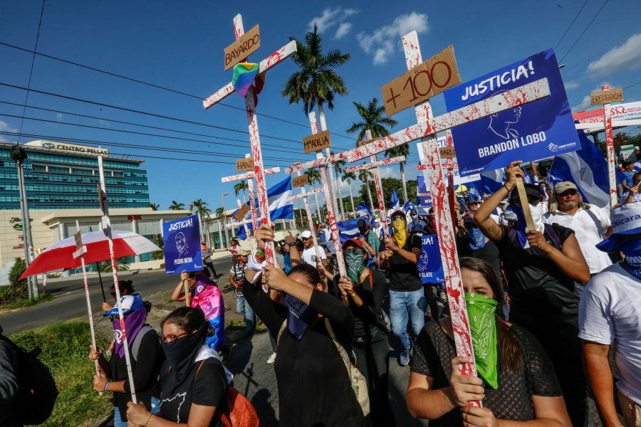 Alfredo Zuniga/TT | Demonstranter i Nicaraguas huvudstad Managua tidigare i augusti bär kors med röd färg för att protestera mot regeringen och våldet i landet.