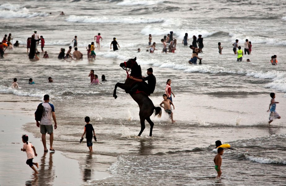 Khalil Hamra/AP Photo/TT  |  Badande på stranden utanför Gaza City.