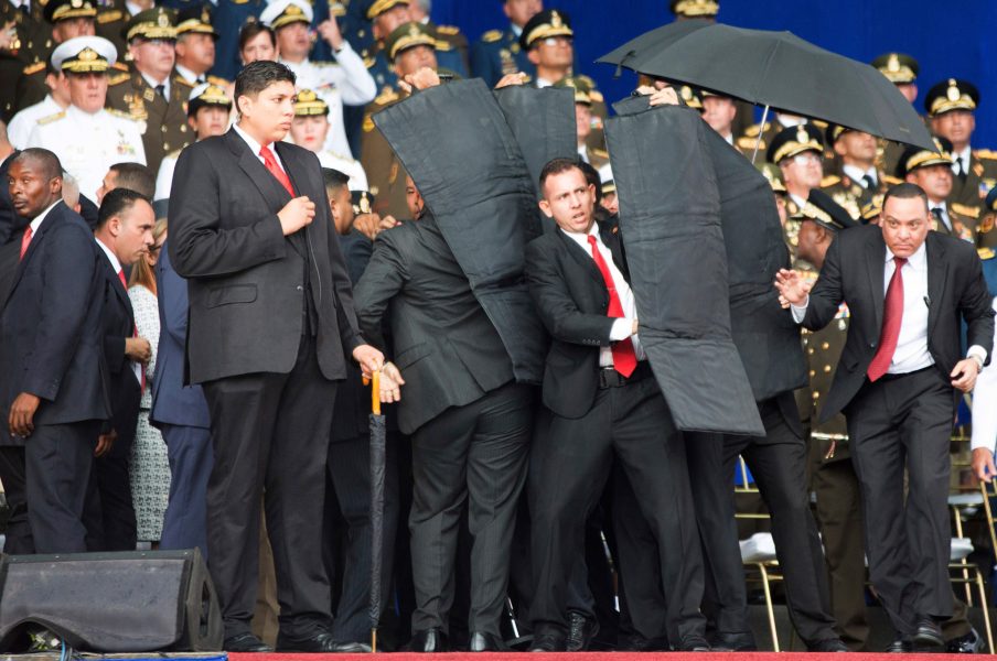 Xinhua/AFP/TT | Säkerhetspersonal omringar Nicolas MAdura och skyddar honom med bombmattor.