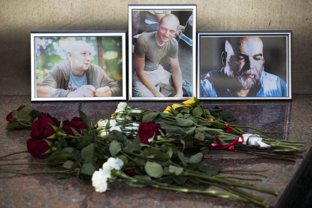 Pavel Golovkin/AP/TT | Blommor har lagts ut vid foton av de tre mördade journalisterna utanför det ryska journalistförbundets byggnad i Moskva.
