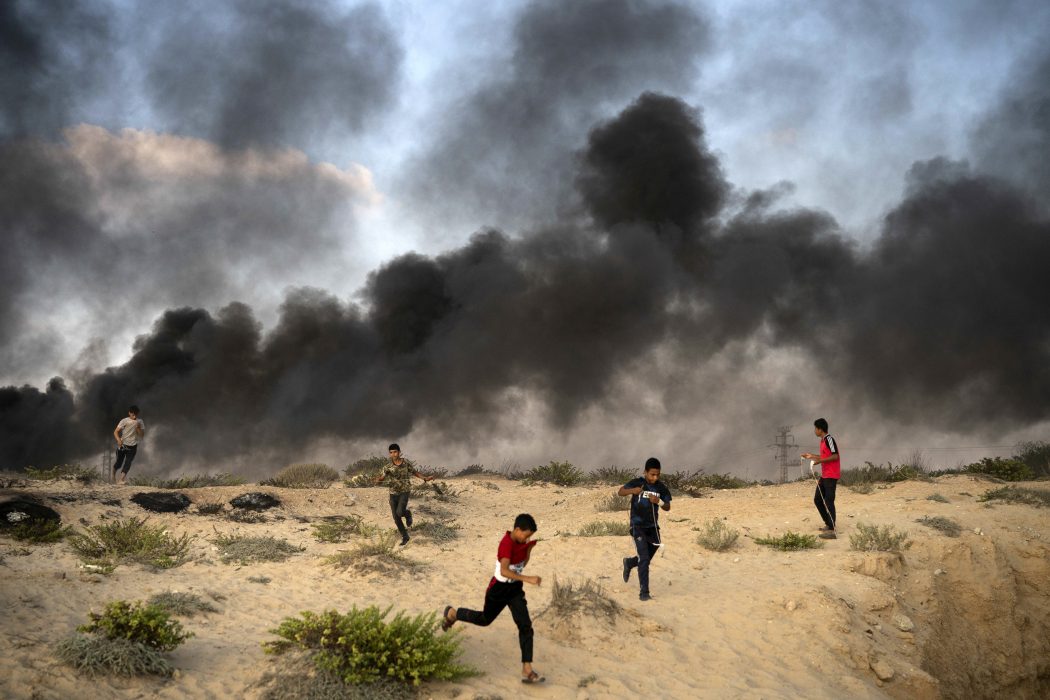 Unga palestinier springer från en protest i närheten av gränsen tidigare i veckan för att undvika tårgas och bli skjutna.