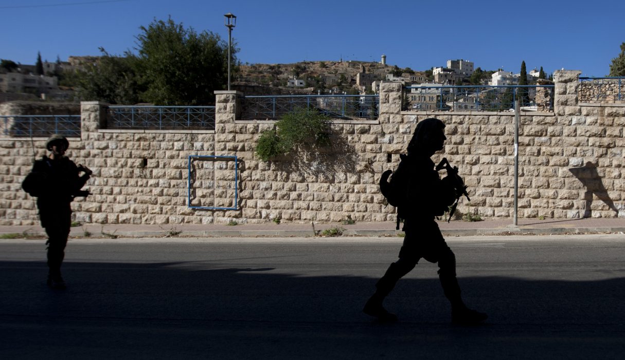 Israeliska soldater patrullerar bosättningen iHebron på den ockuperade Västbanken.
