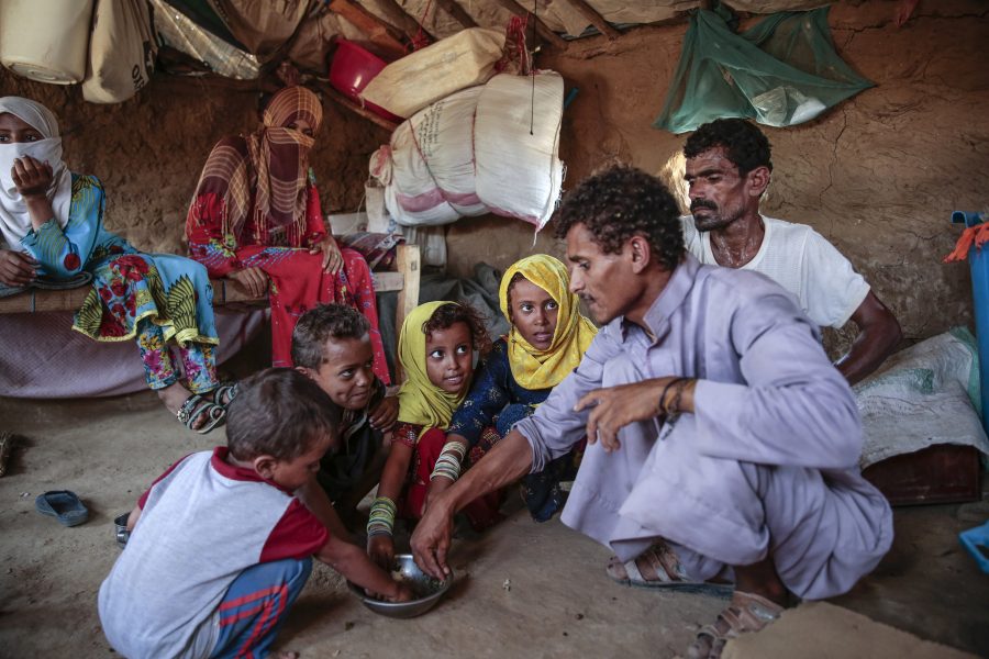 Hani Mohammed/AP/TT | En man ger barn mat i Aslam i Jemen.