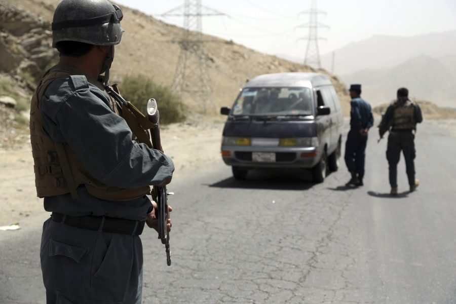 Rahmat Gul/AP/TT | Afghanska poliser söker igenom ett fordon vid en motorväg väster om Kabul.