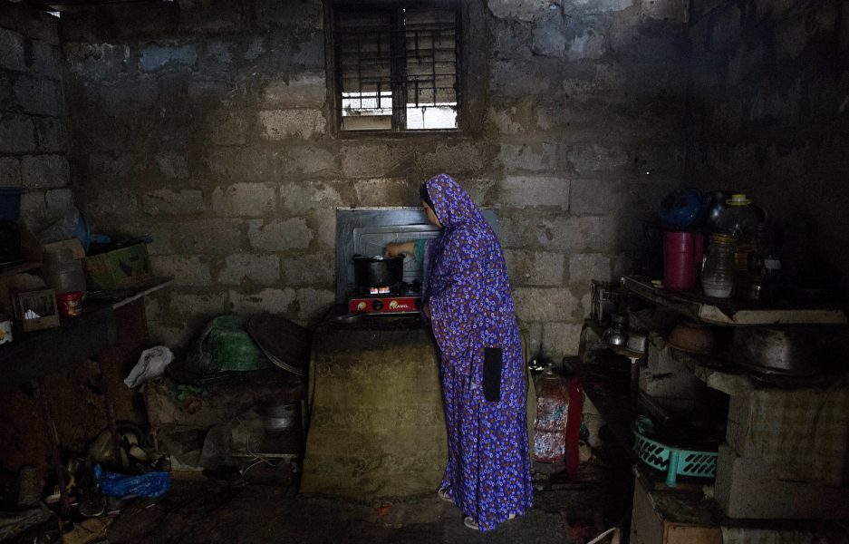 En kvinna lagar mat i ett fattigt slumområde i utkanten av Khan Younis i södra Gazaremsan.