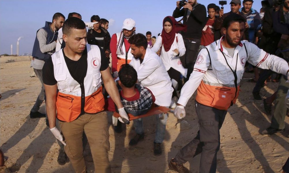 Läkare evakuerar en sårad ungdom vid gränsen till Gaza.