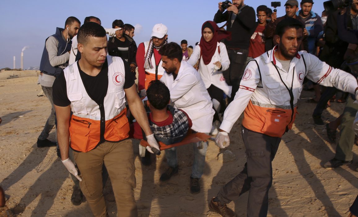 Läkare evakuerar en sårad ungdom vid gränsen till Gaza.