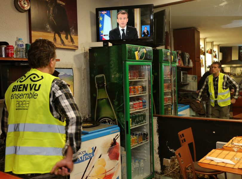 En anhängare till Gula västarna tittar på president Emmanuel Macrons tv-sända tal på måndagkvällen.