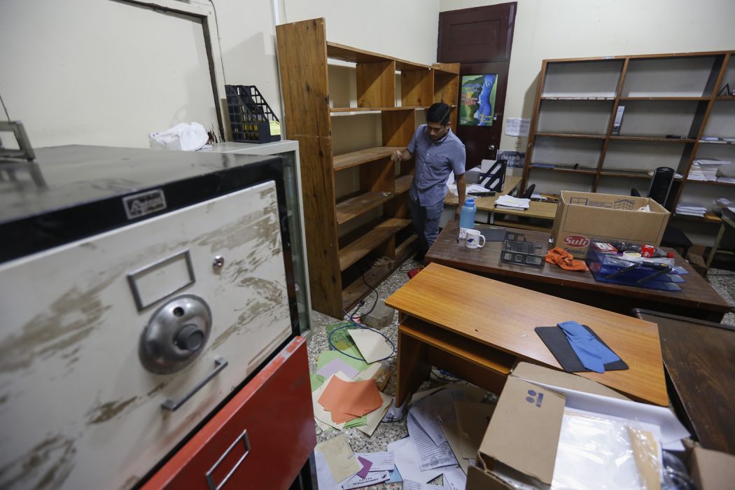 En anställd vid den svartlistade organisationen Fundación Popol Na går igenom kontoret i Managua efter polisens husrannsakan på fredagen.
