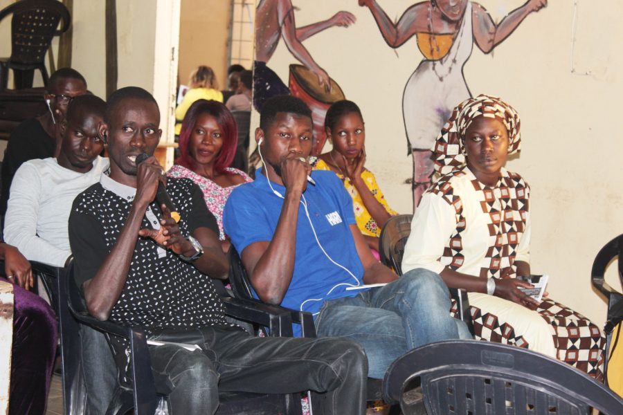 En ung man i Dakar deltar vid en av de diskussioner som anordnas inom IOM-kampanjen ”Migranter som budbärare”.