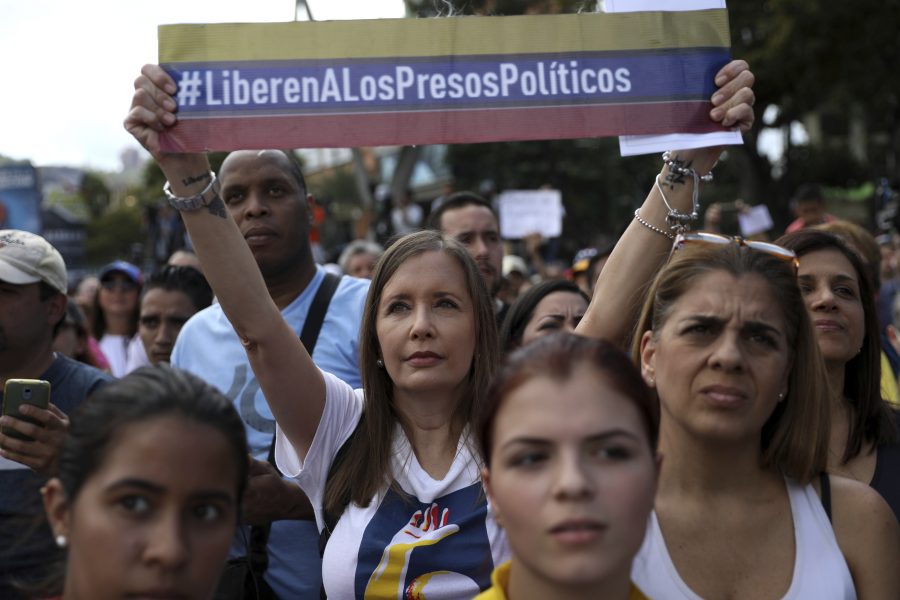 En kvinna håller upp en banderoll med budskapet: "Befria de politiska fångarna" under en demonstration i Caracas i lördags.