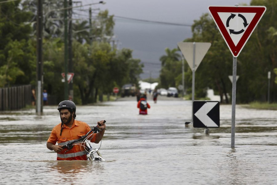 En invånare försöker ta sig fram på en översvämmad gata i Townsville i Queensland, Australien.