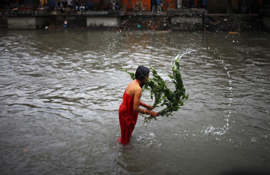 Kvinna i Nepal piskar sig själv med vövruska som en ritual för att tvätta bort skammen med menstruation.
