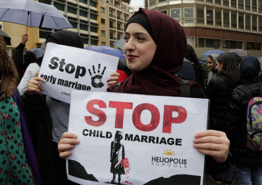 Libanesiska kvinnor håller upp plakat under demonstrationen mot barnäktenskap.
