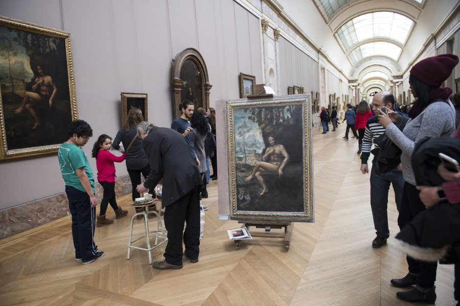 På Louvren står en konstnär och för över en annan konstnärs bild till sin egen duk efter bästa förmåga.