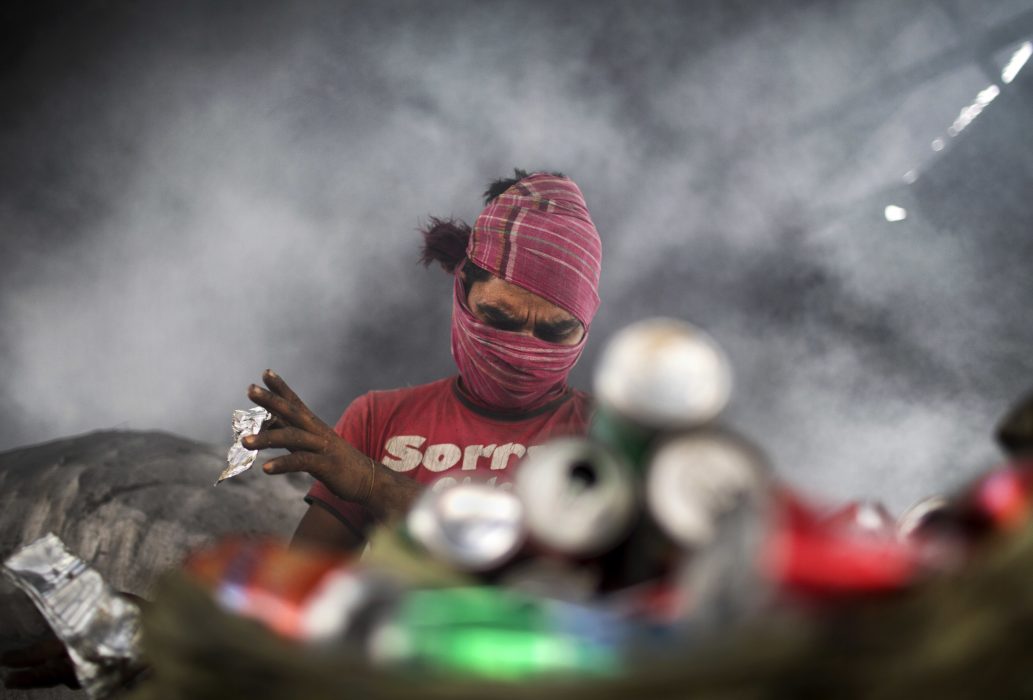 Migrantarbetare sorterar metallskrot i utkanten av Dhaka, Bangladesh.