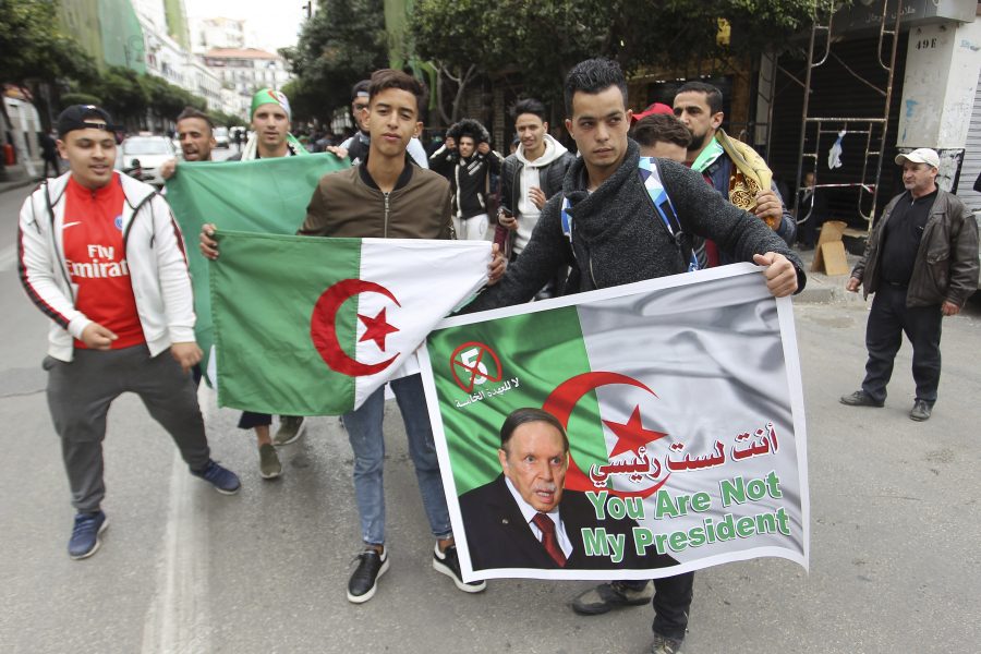 Unga demonstranter med bilder på president Abdelaziz Bouteflika och algeriska flaggor i Alger på fredagen.