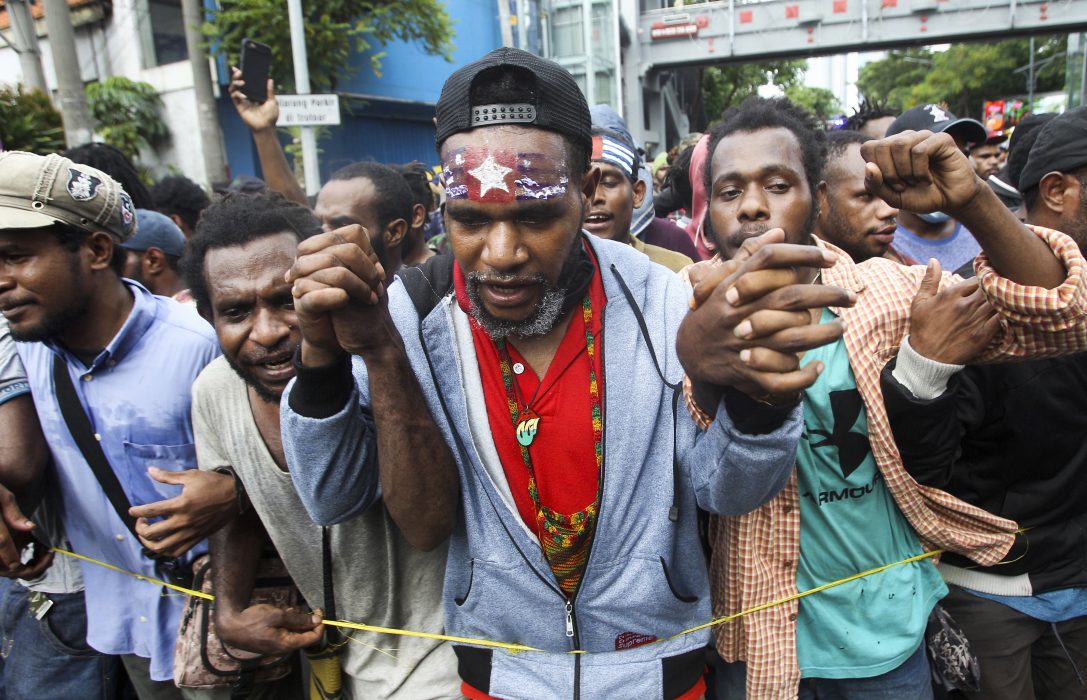 Aktivist från Västpapua med den förbjudna flaggan ”Morning star” målad i pannan, under en demonstration i Surabaya, Indonesien.