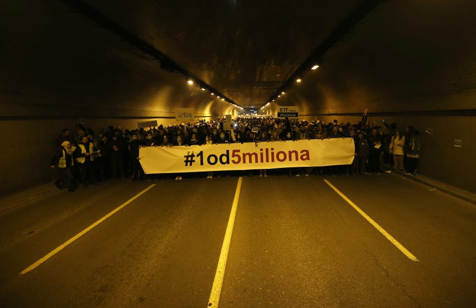 Demonstranter håller upp en banner med texten ’1 av 5 miljoner.