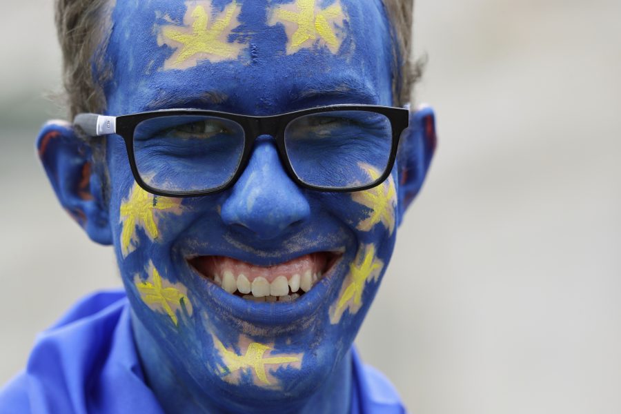 En demonstrant med ansiktet målat som EU-flaggan.