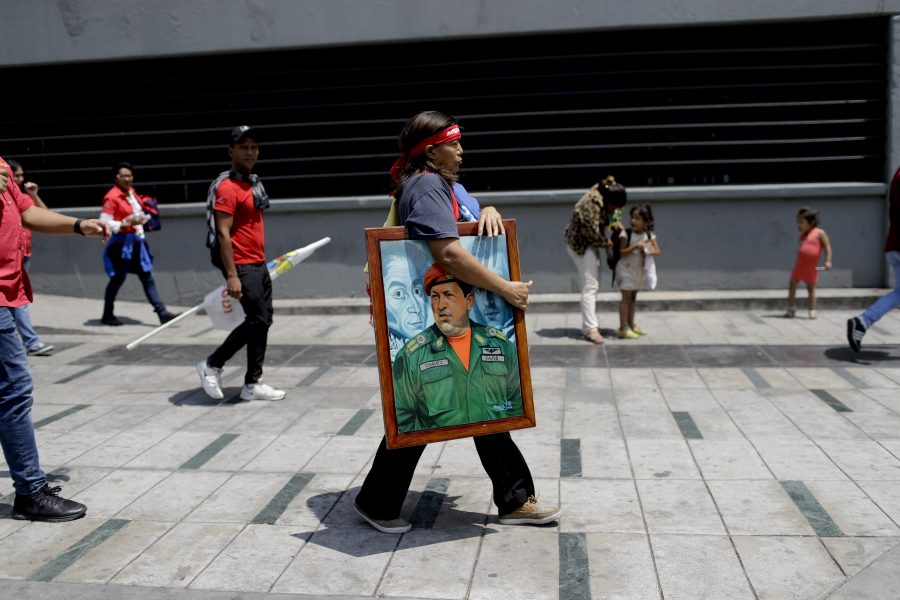 Esther Lopez, bär en tavla av förre presidenten Hugo Chavez under en march för fred i Caracas.