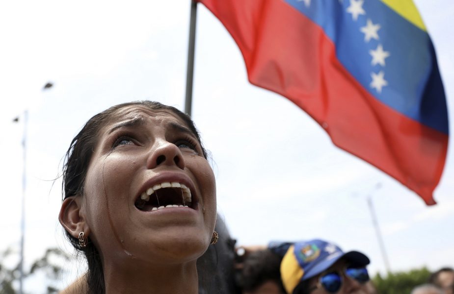 Yanela Aleman gråter när hon sjunger den venezolanska nationalsången i La Parada, Colombia, vid gränsen till Venezuela.