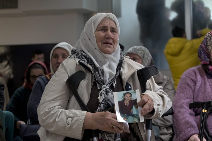 Kvinna som håller en bild på sin son, offer för folkmordet.